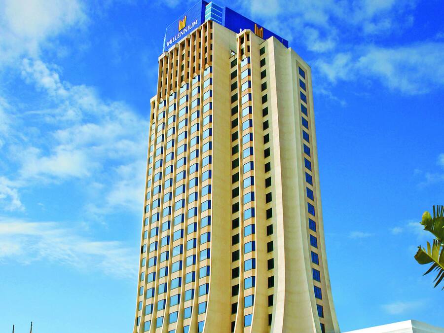 Un hotel alto con una fachada curva distintiva y un letrero llamativo en la parte superior.