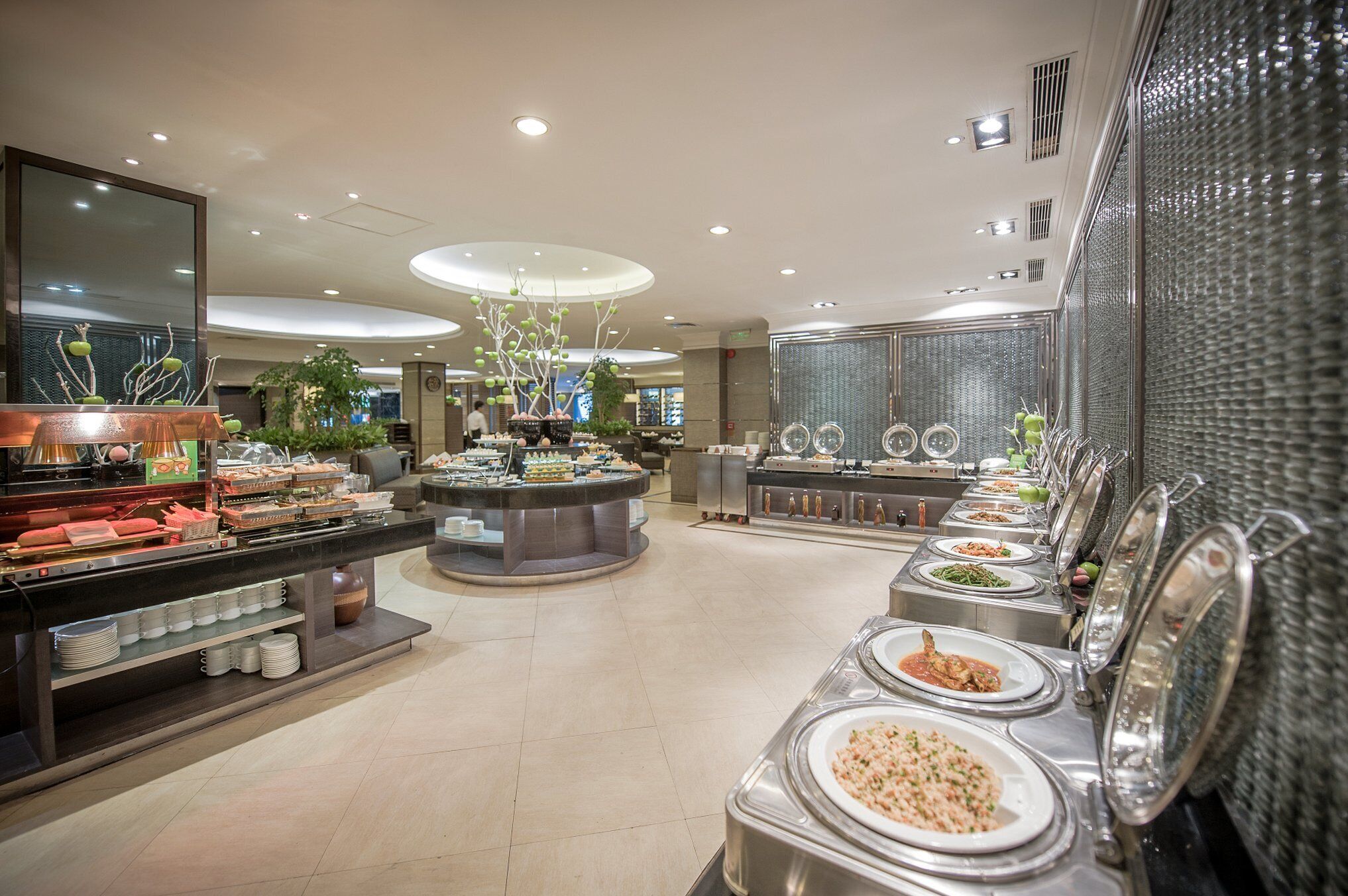 A buffet area with various food stations and a central serving counter.