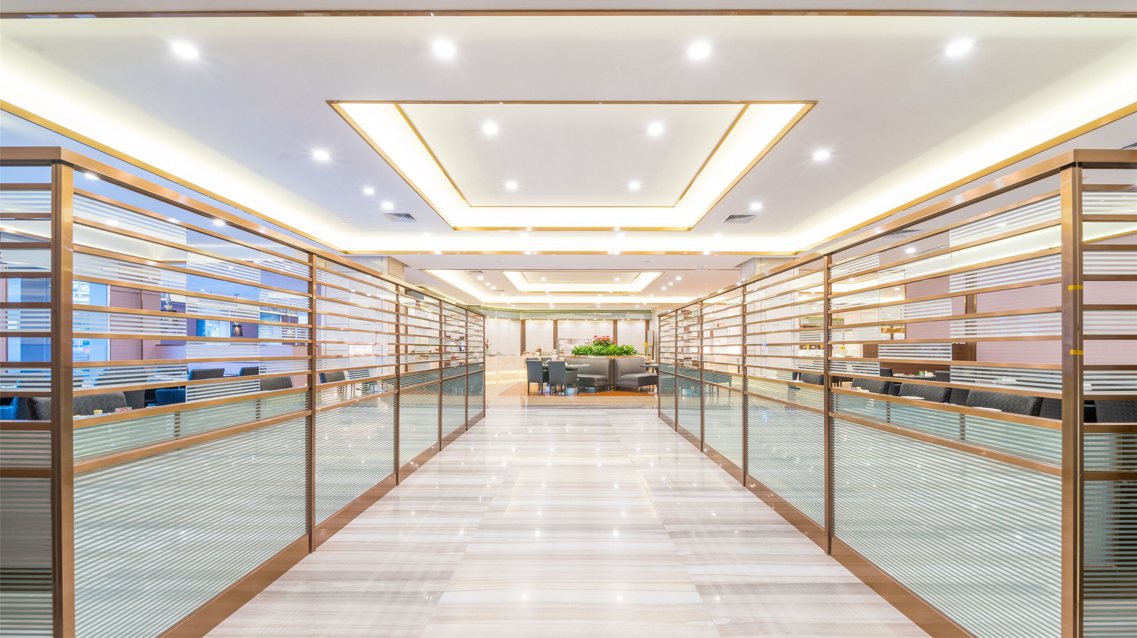 A modern interior with a central dining area, glass partitions, and a polished floor.