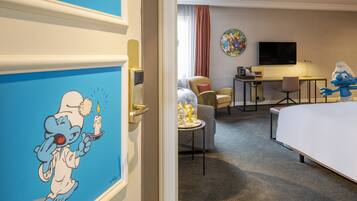 A hotel room with a bed, desk, chair, and a television.