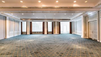 Un hall d’hôtel spacieux, doté d’un sol à motifs géométriques, de grandes fenêtres et d’un design moderne au niveau du plafond.