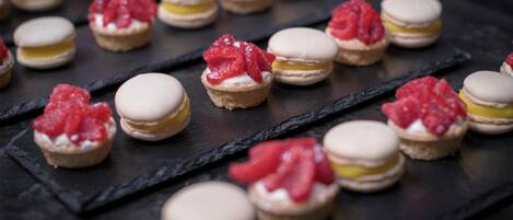 Macarons dispuestos sobre una tabla de pizarra.