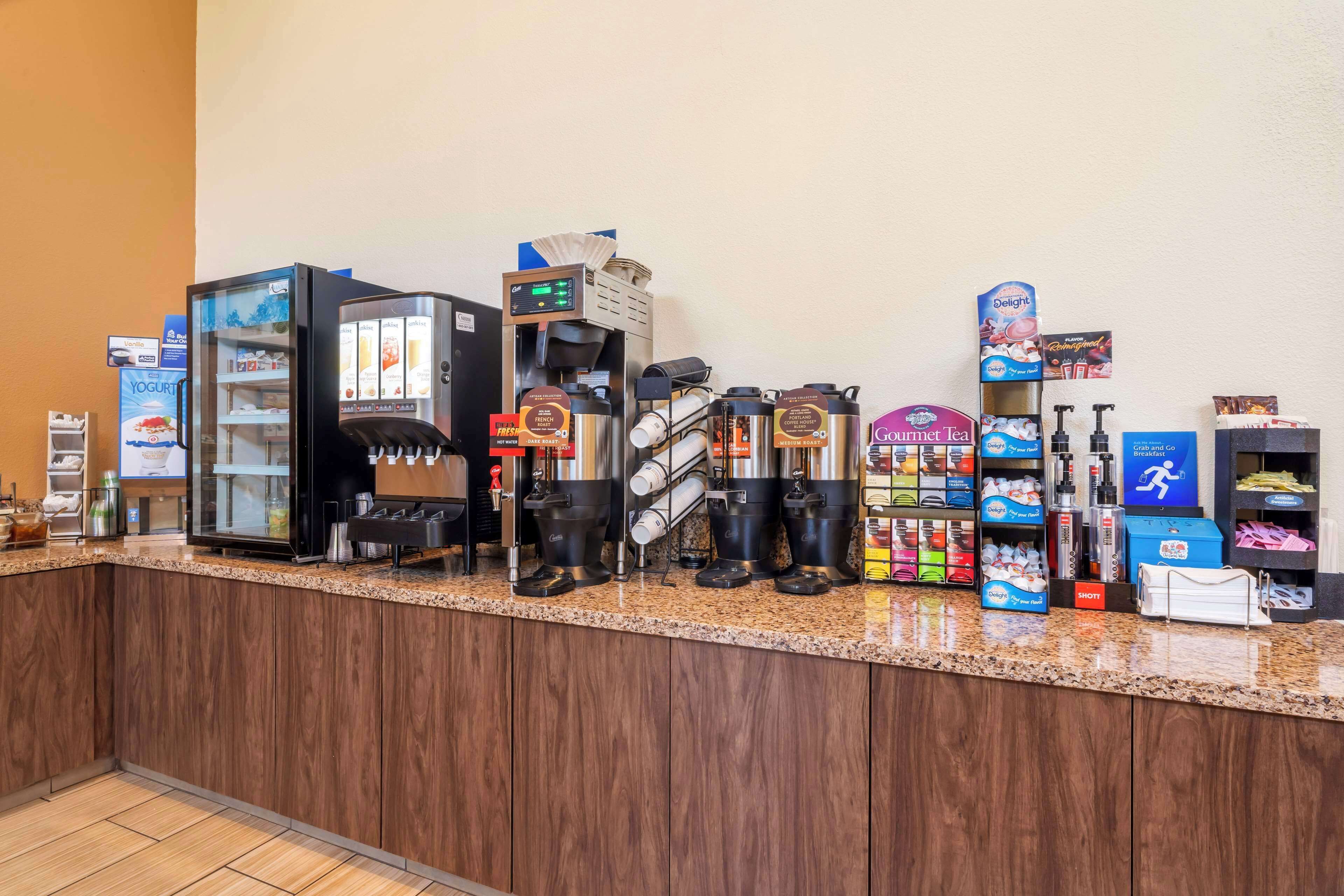 A coffee station with multiple coffee machines, a yogurt dispenser, and various beverage dispensers.