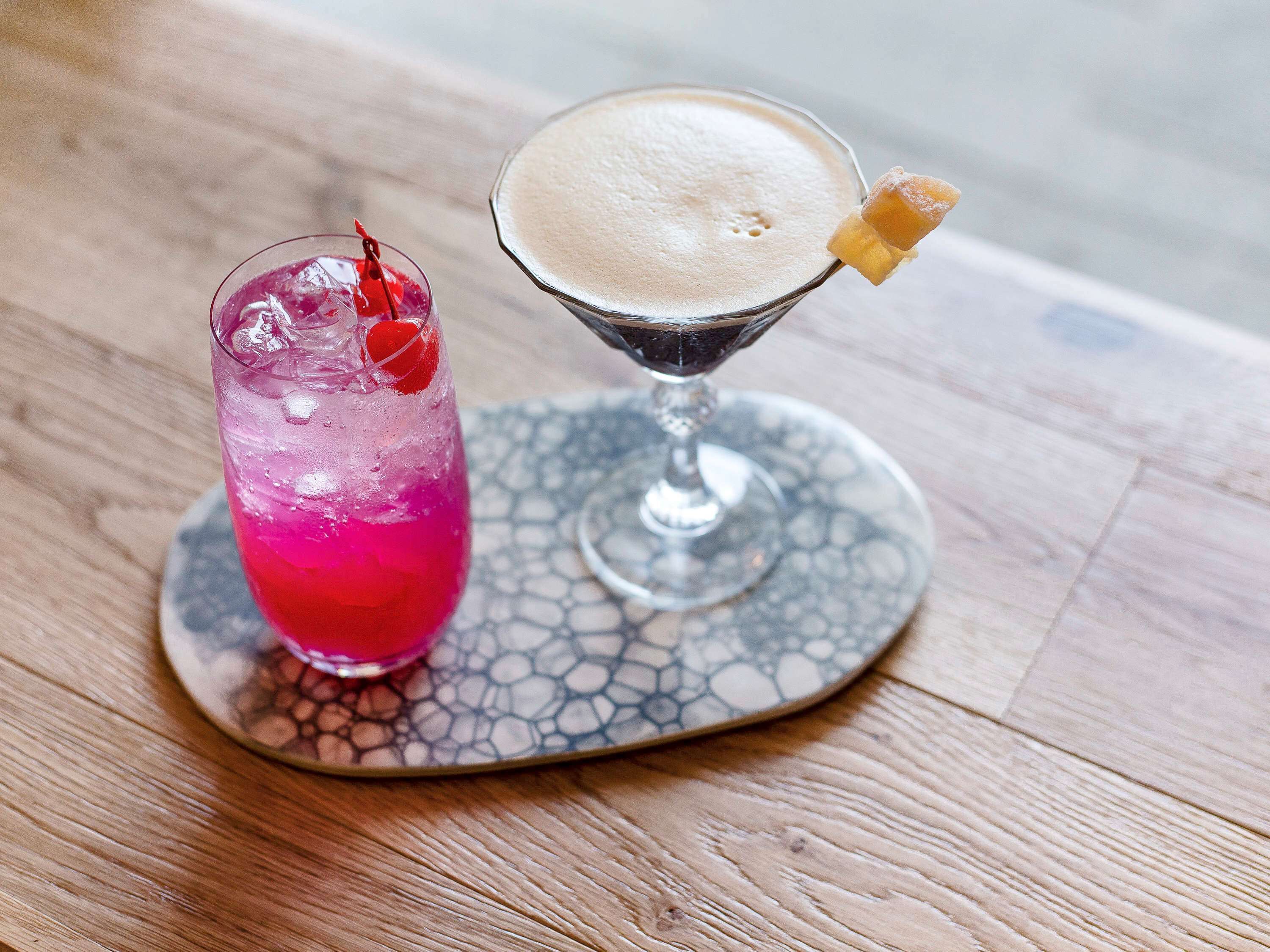 Deux boissons sur une table, accompagnées d’un sous-verre à motifs.