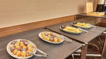 A hotel dining area with tables set for breakfast.