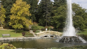 A park with a fountain, a wooden bridge, and a bench. - Holiday Inn Bangor by IHG (Bangor)