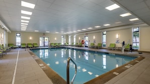 An indoor swimming pool with multiple lanes, green chairs around the pool, and a lifeguard chair. - Holiday Inn Bangor by IHG (Bangor)
