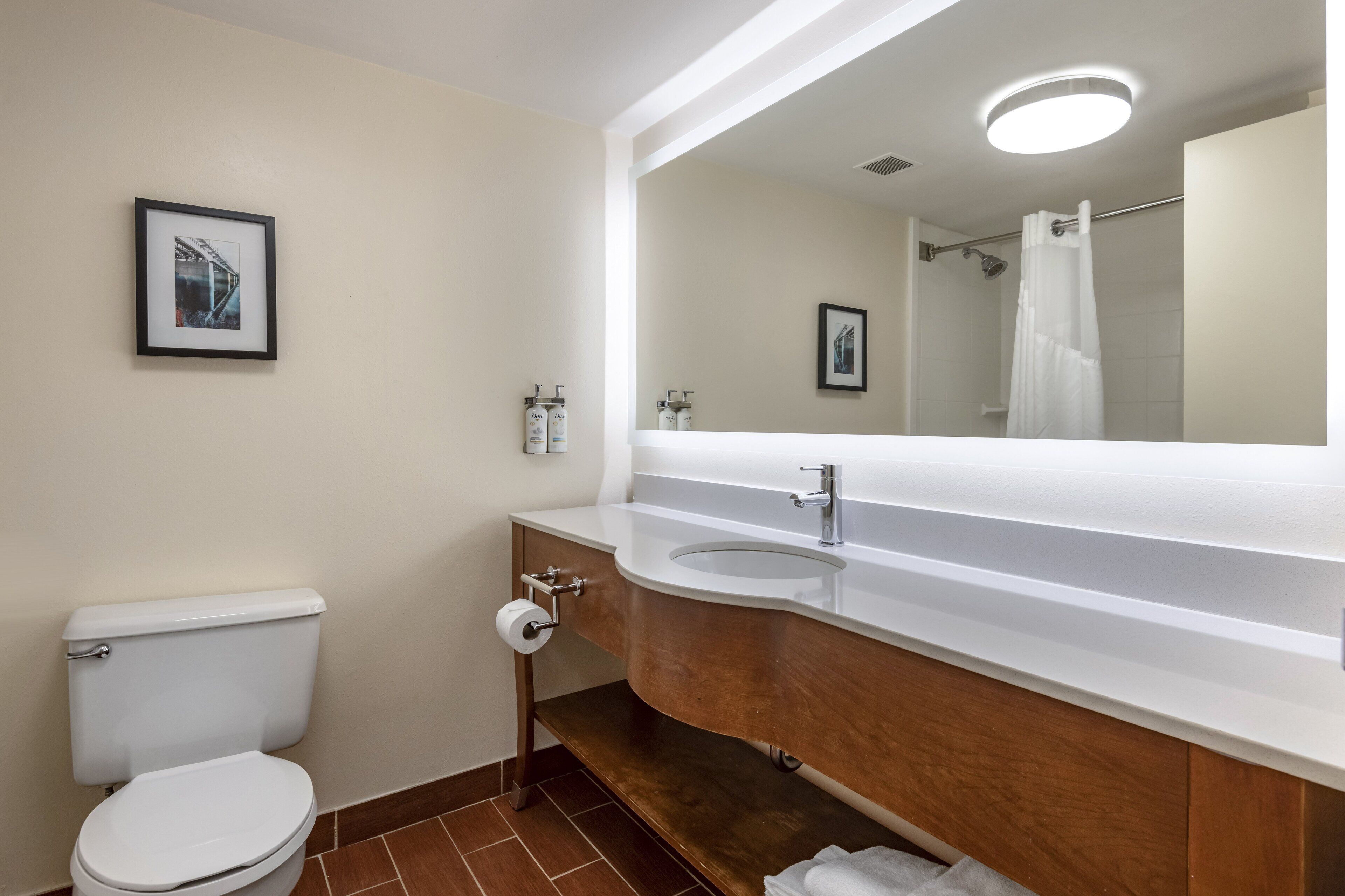 A modern bathroom with a toilet, sink, and mirror.