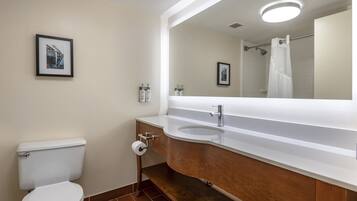 A modern bathroom with a toilet, sink, and mirror.
