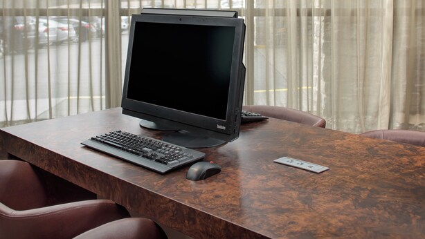 Une table de conférence équipée d’un ordinateur, d’un clavier et d’une souris.