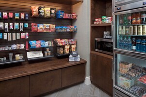 A snack display with various brands and a refrigerated section with beverages.