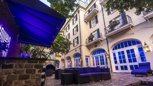 Un cortile con posti a sedere all'aperto, pareti in pietra e una piscina.