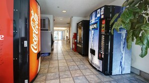 A hallway with vending machines, including a Coca-Cola cooler and a Dasani water dispenser.