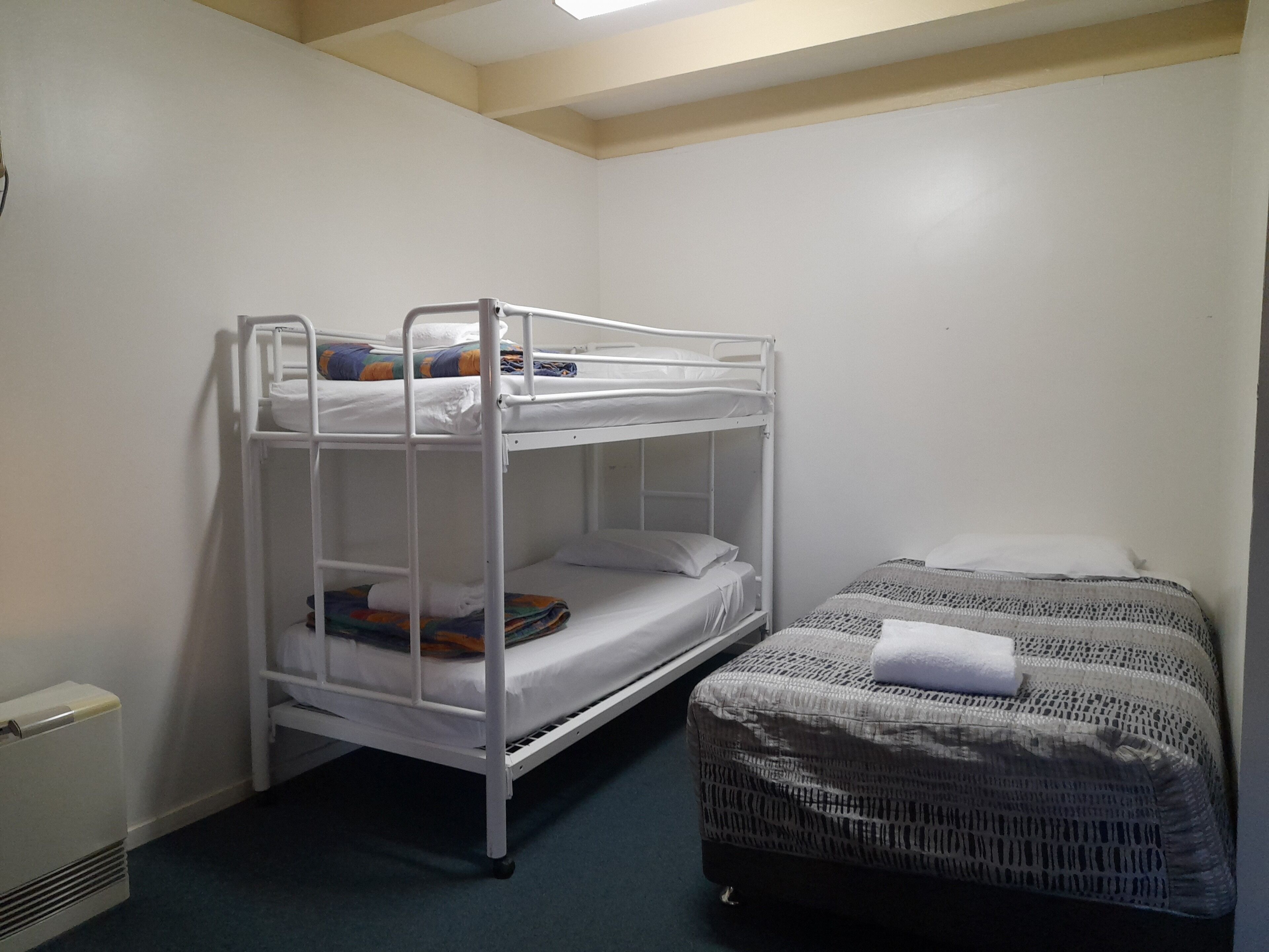 A bunk bed room with a single bed and a small table.