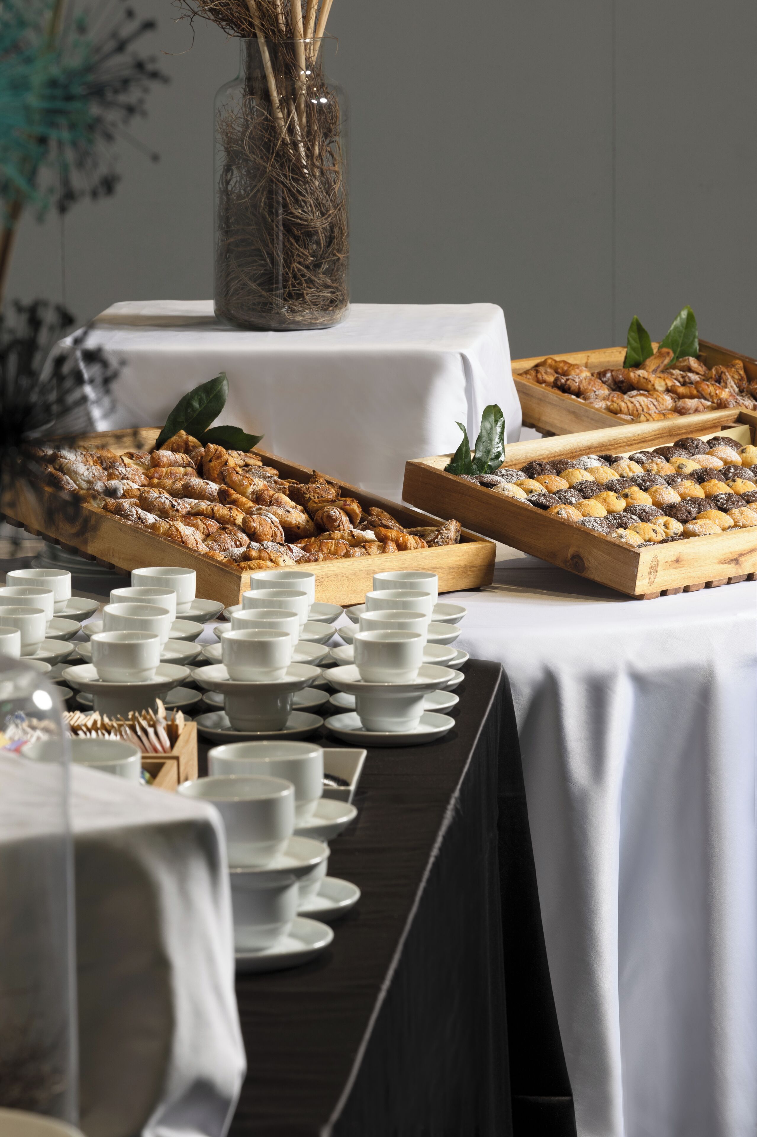 Ein reichhaltiges Buffet mit verschiedenen Backwaren und einer Vase mit Trockenblumen.