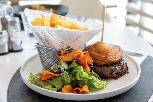 A plate with a burger, fries, and a salad. - ibis La Baule Pornichet Plage (Pornichet)