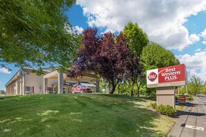 A Best Western Plus sign with a Prairie Inn logo, a parking lot, and a building with a covered entrance.