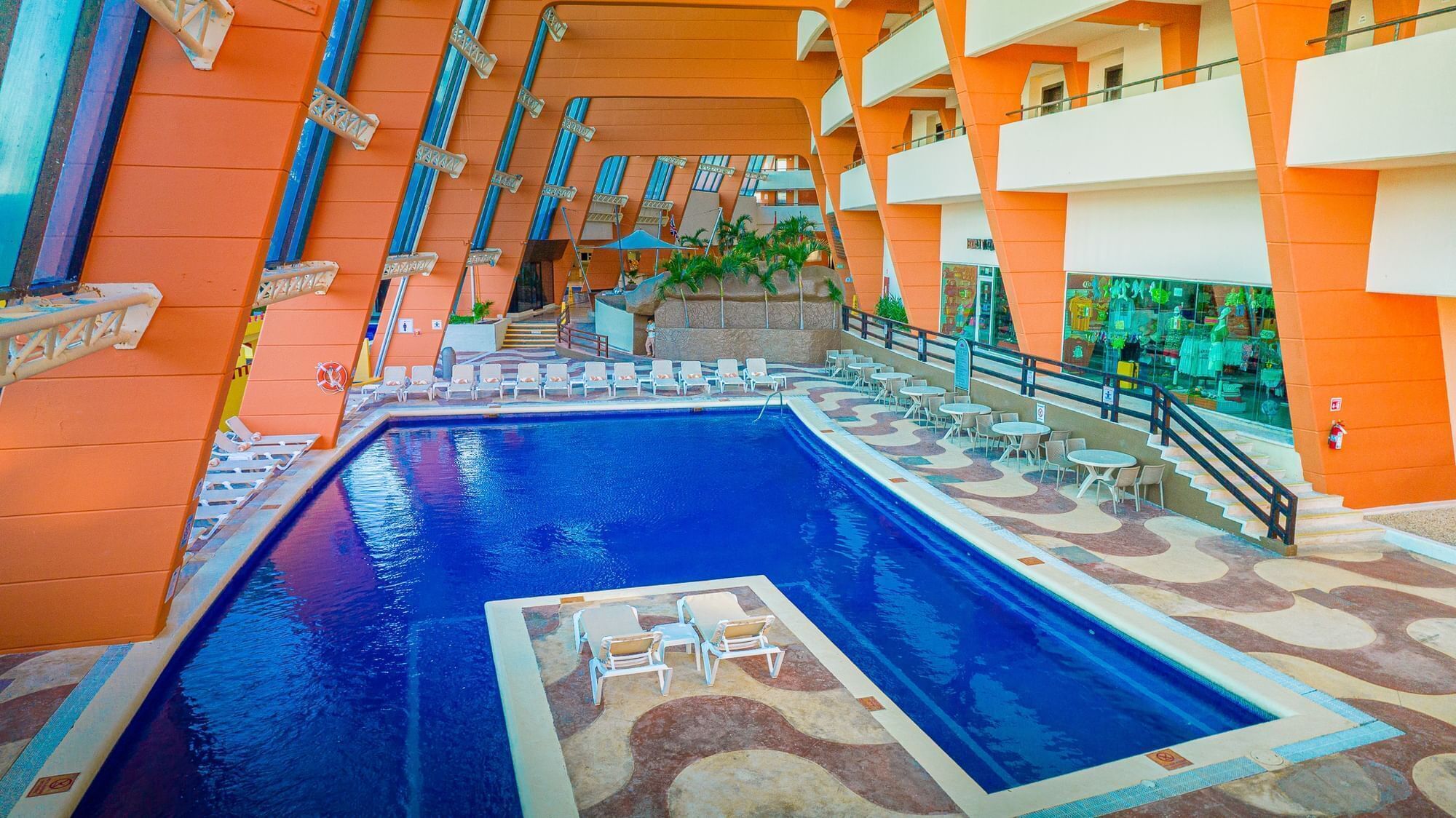 Una gran piscina interior amb múltiples balcons i zones d'estar.