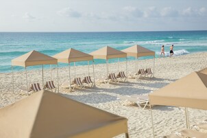 On the beach, white sand, sun loungers, beach umbrellas