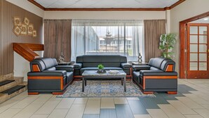 Una sala de estar moderna con un conjunto de sofás, una mesa de centro y vistas a un edificio.