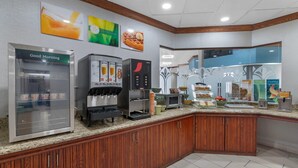 Una barra de desayuno equipada con refrigerador, cafetera y microondas.