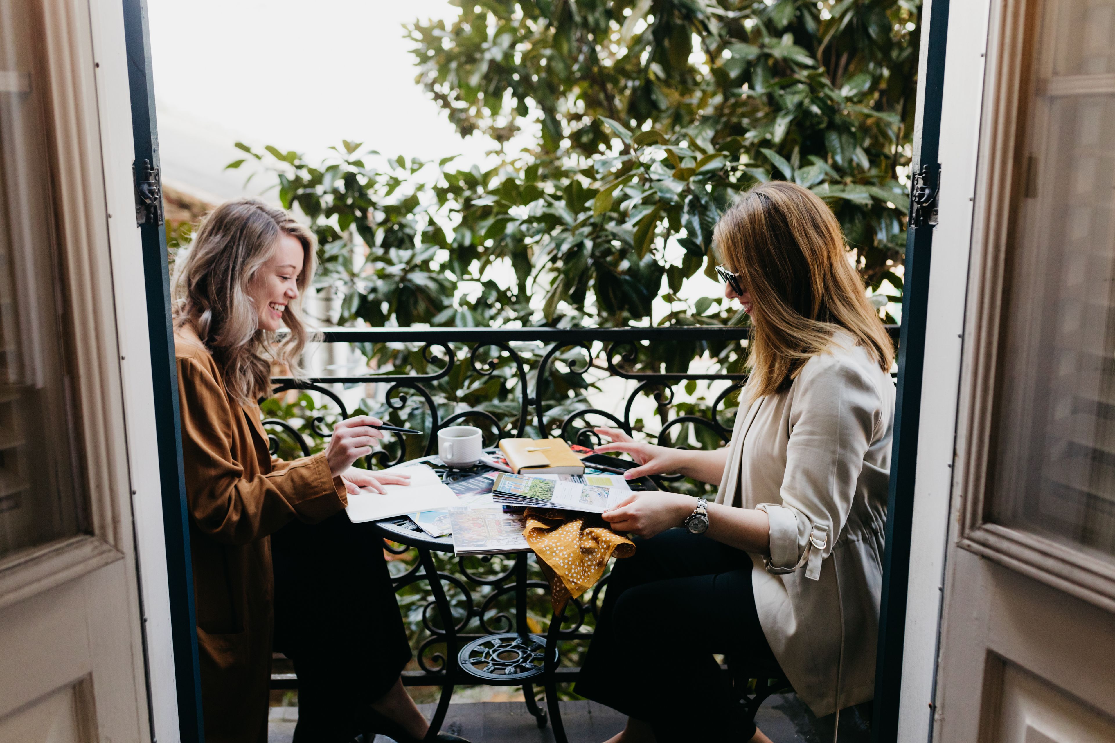 Dos personas sentadas en una mesa con vista a un jardín.