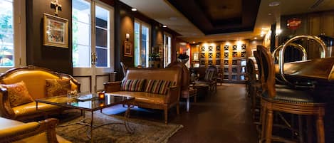 A spacious lobby with leather sofas, a coffee table, and a patterned rug.