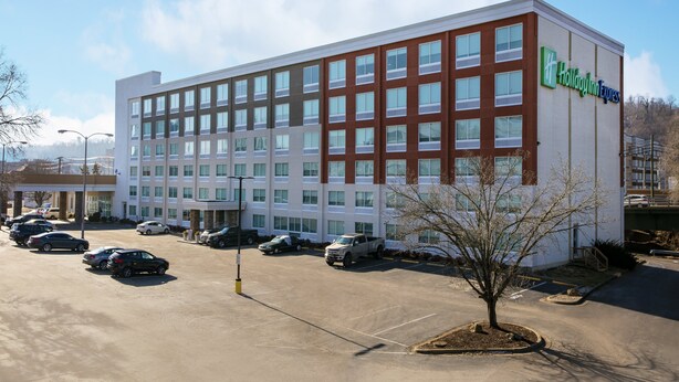 A Holiday Inn Express building with a parking lot and several cars.