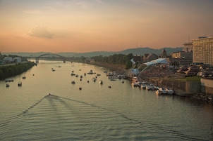 A river with boats, a bridge, and buildings along the banks.