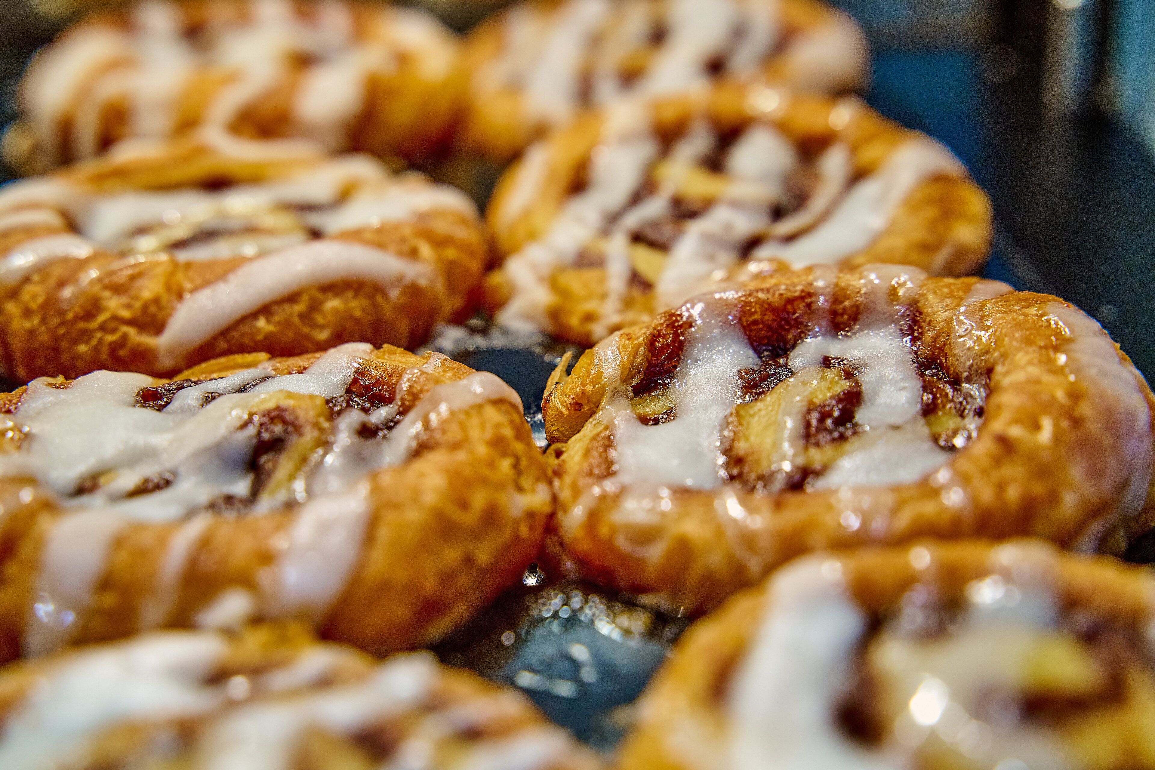 A close-up of cinnamon rolls with icing.