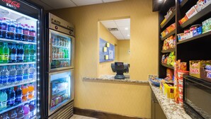 A vending area with a Coca-Cola Zero fridge, a Twix chocolate dispenser, and a variety of snacks and drinks.