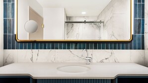 A modern bathroom with a large mirror, a sink, and a shower. - Holiday Inn Downtown - Missoula by IHG (Missoula)