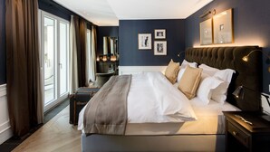 Un dormitorio moderno de hotel con una cama grande, una mesita de noche, una lámpara y vistas al exterior.