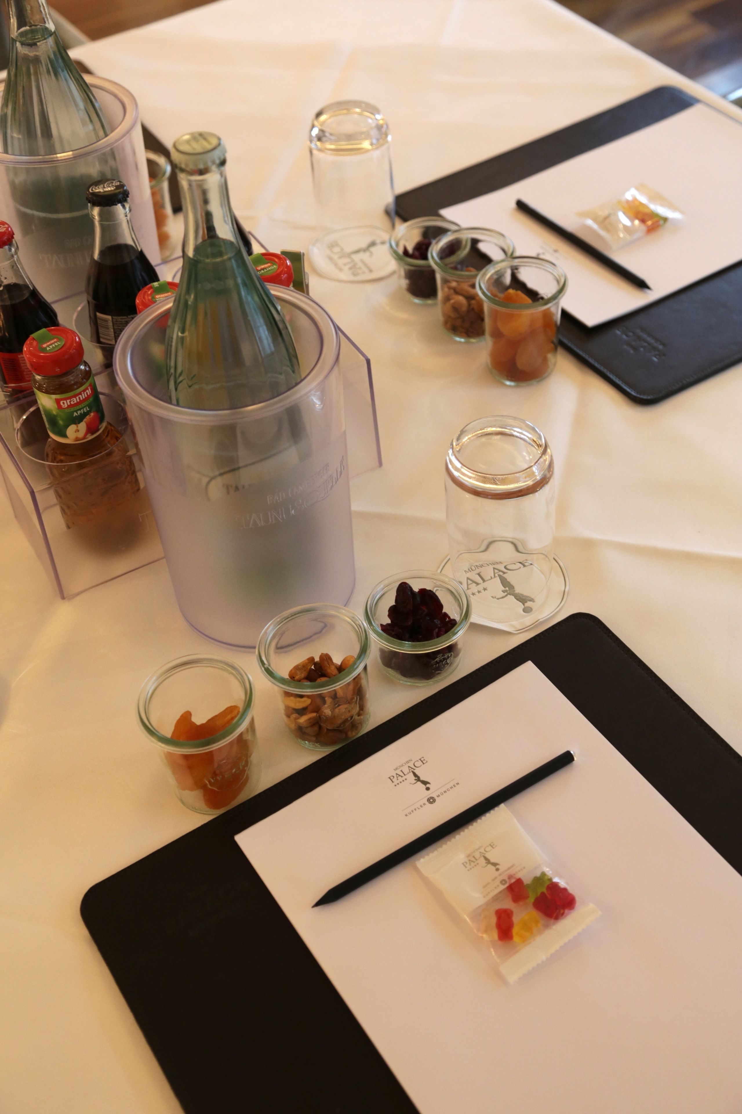 A table with various items including bottles, jars, and a tablet with a pen.