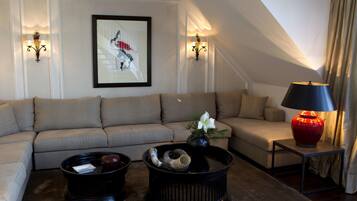A modern living room with a sectional sofa, two black coffee tables, a red vase, and wall-mounted lamps.