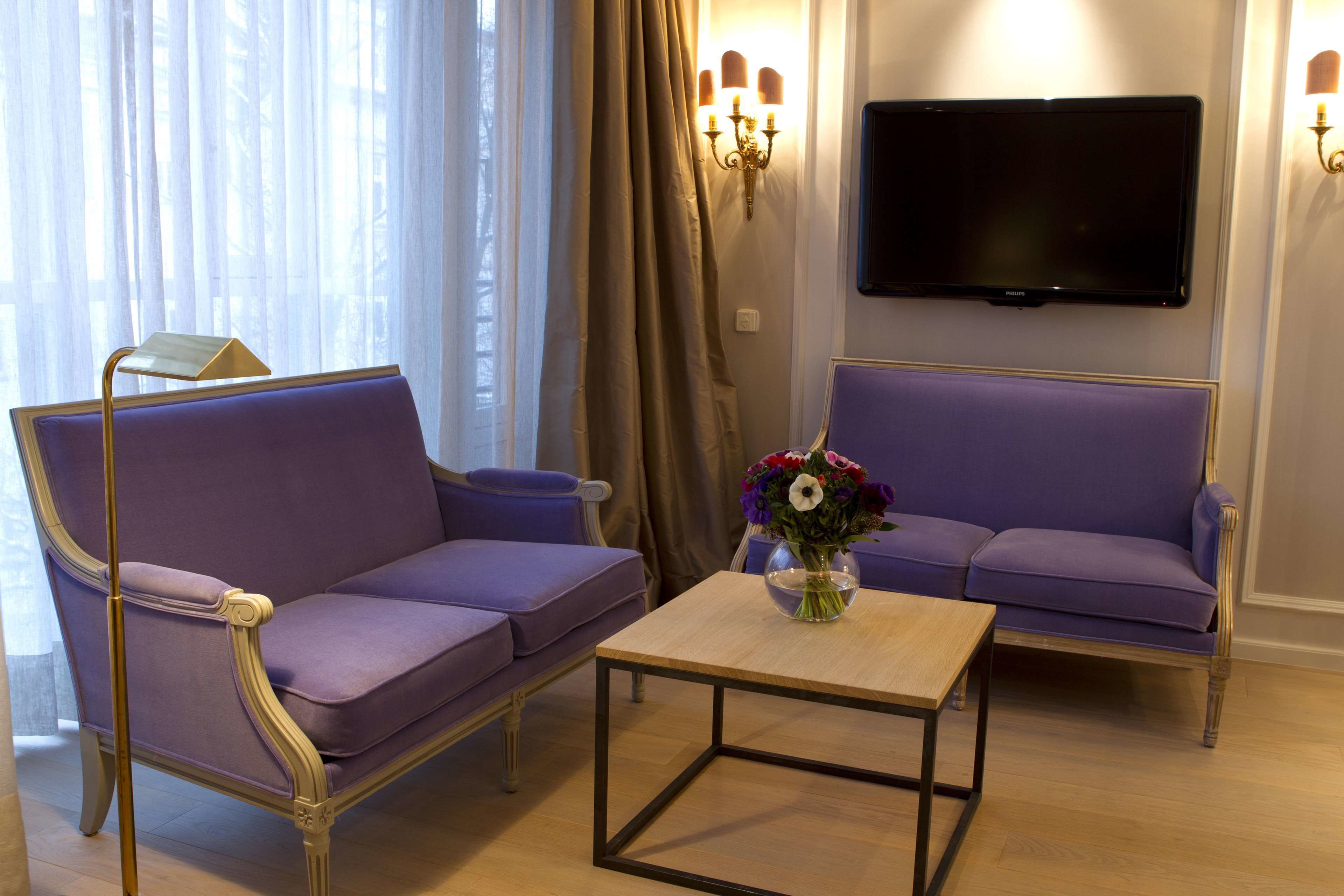 Un salon comprenant un canapé, une table basse et un téléviseur à écran plat fixé au mur.