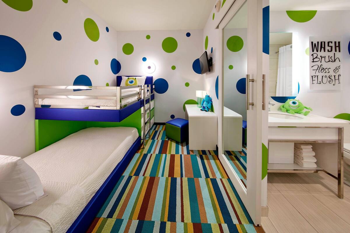 A child's bedroom with bunk beds, a colorful striped carpet, and a mirror with a 'WASH BRUSH FLOSS & FLUSH' sign.