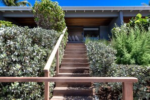 A staircase leading to a building with a wooden exterior and a covered area at the top.