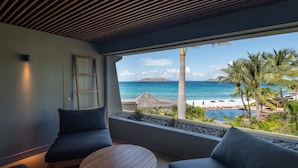 A room with a view of the ocean, a wooden ceiling, and a seating area with a round table. - Christopher Hotel (St. Barthelemy)