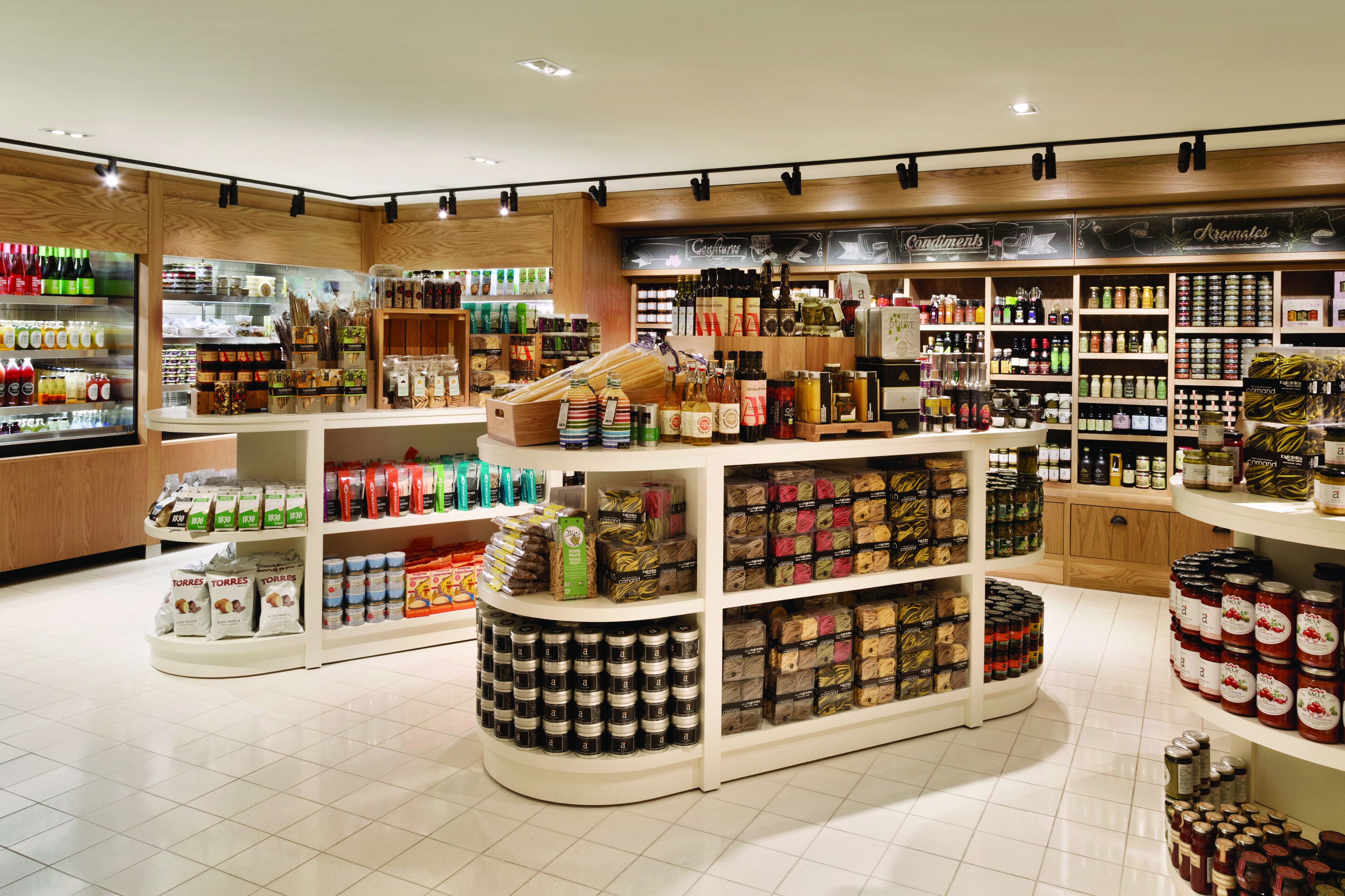 A well-organized store with shelves stocked with various food items, condiments, and packaged goods.