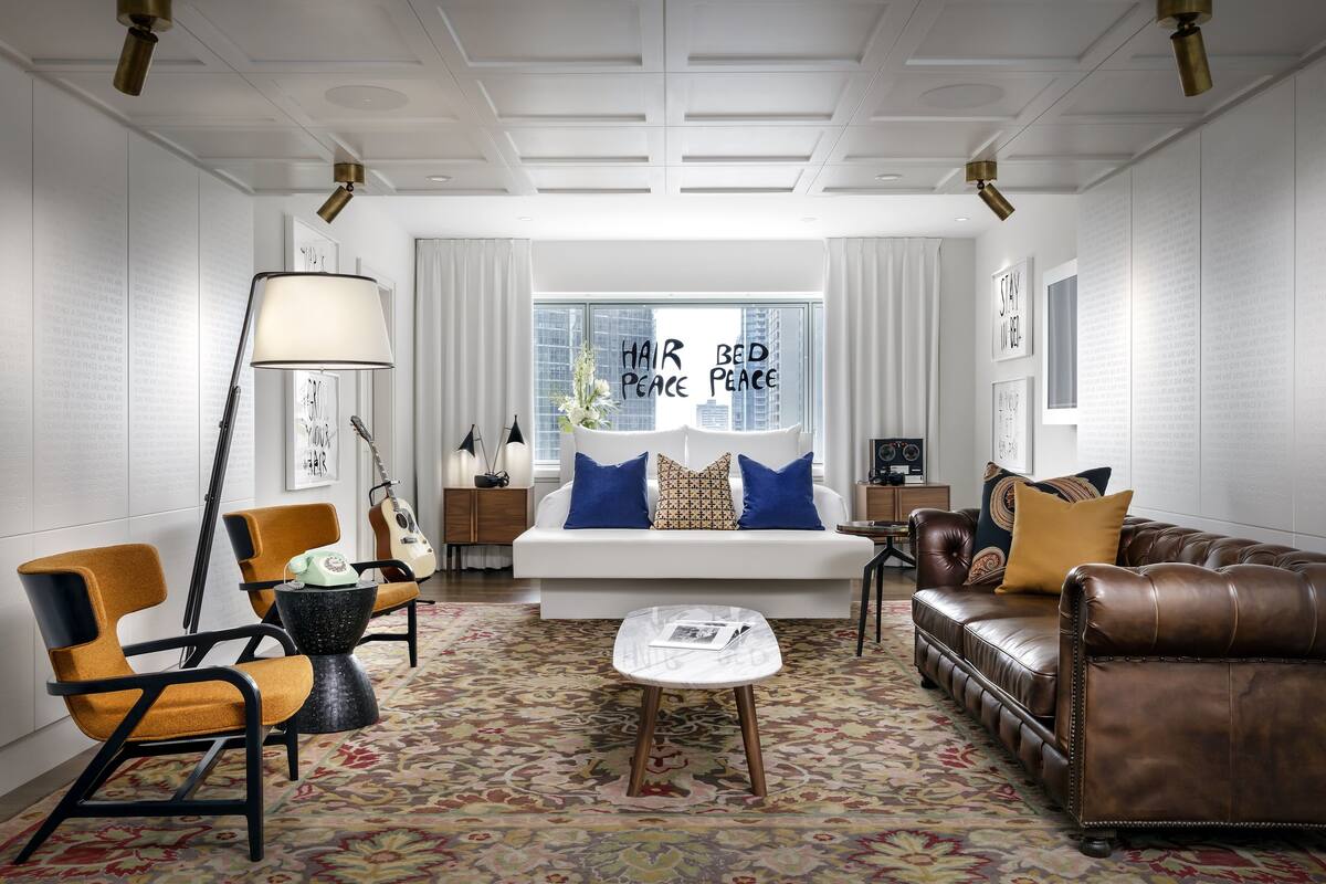 A modern living room with a sofa, armchairs, a coffee table, and a lamp.
