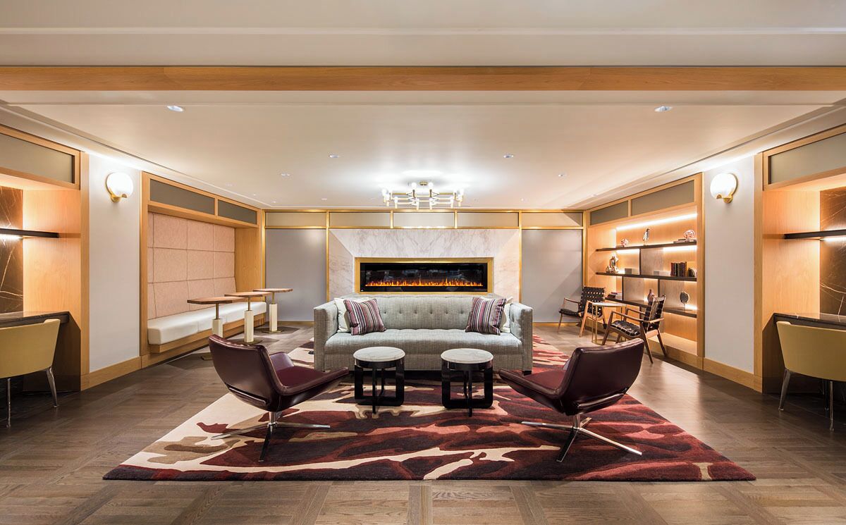 A modern living room with a fireplace, sofas, and a coffee table.
