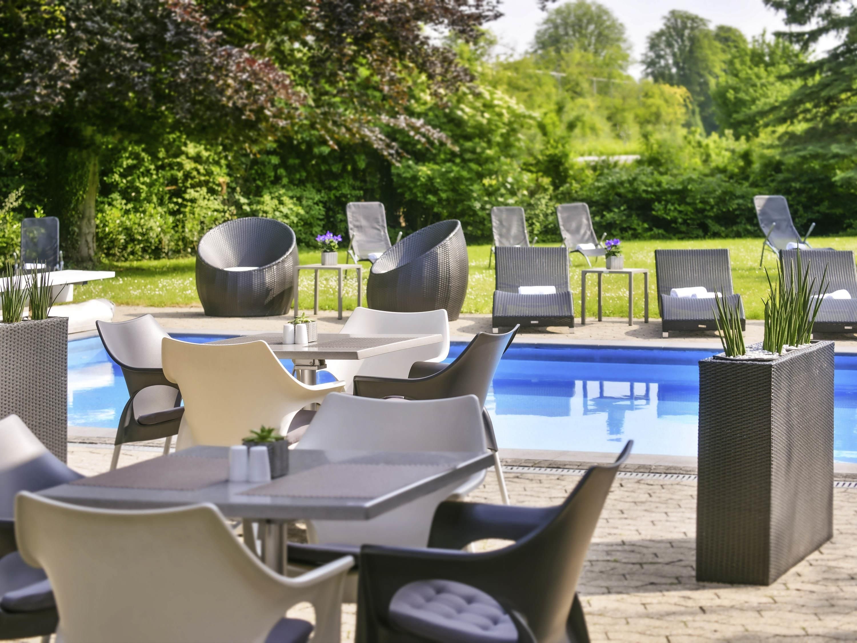 Ein Poolbereich mit Liegestühlen, einem Tisch und einem Pool.