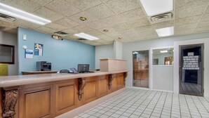 A reception area with a wooden counter, tiled floor, and blue walls.