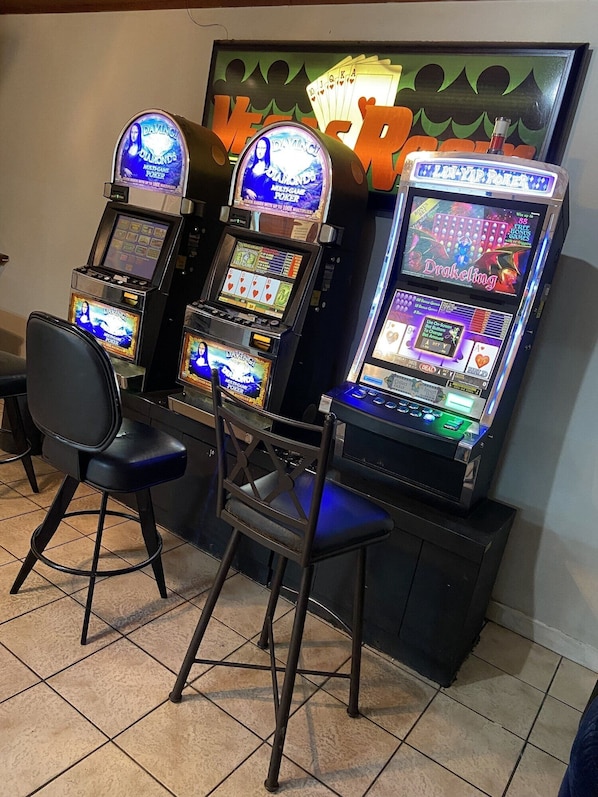 Three slot machines with a chair in front.