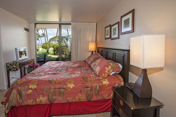 Une chambre d’hôtel avec un grand lit, un bureau avec une chaise, une lampe et une vue sur l’extérieur.