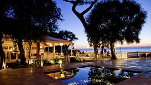 An outdoor terrace with a pool, seating areas, and a view of the sea. - Grand Hotel Cocumella (Sant'Agnello)