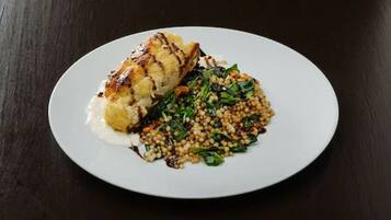 A plate with a piece of grilled chicken, mashed potatoes, and a side of greens.