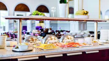 Een buffet met verschillende gerechten en een wijnglas.