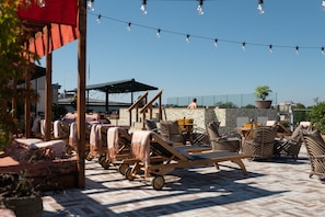 Una piscina al aire libre, sombrillas, sillones reclinables de piscina